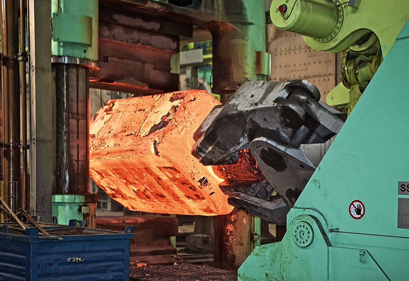 heißes Metall wird mithilfe eines Schmiedemanipulators gehalten